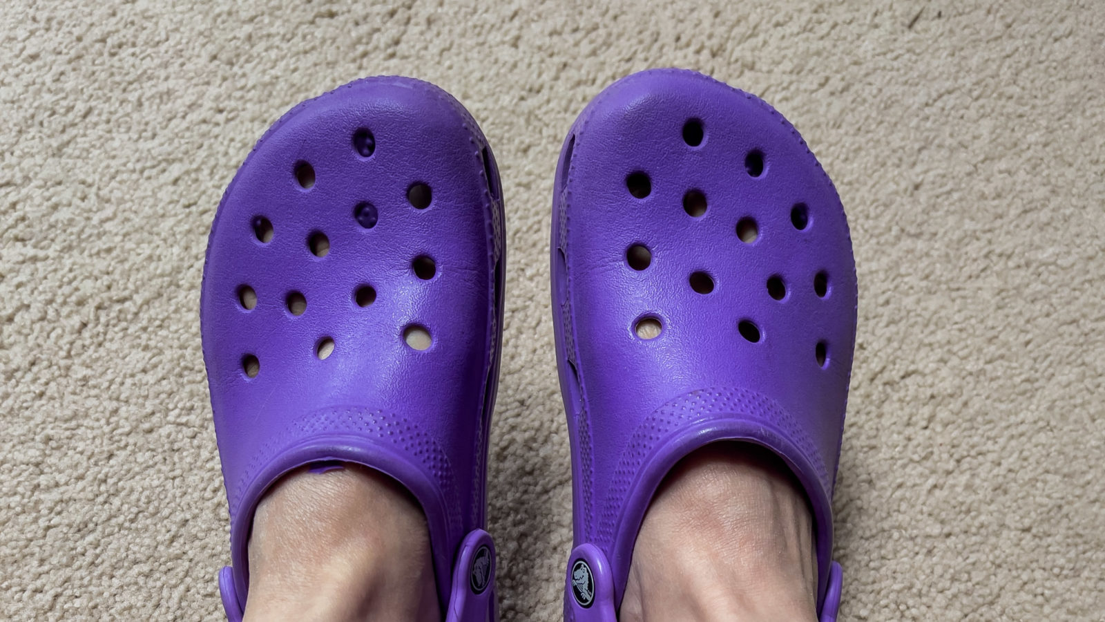 Crocs purple on two bare feet tops