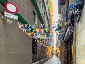 Taste Barcelona on a side pedestrian street in Barcelona with flags across the center.