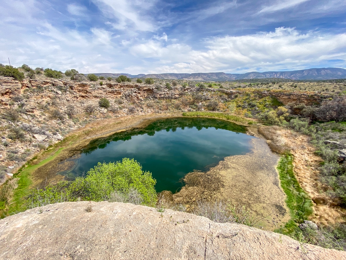 Montezuma Well from viewing platform with mountains in background.